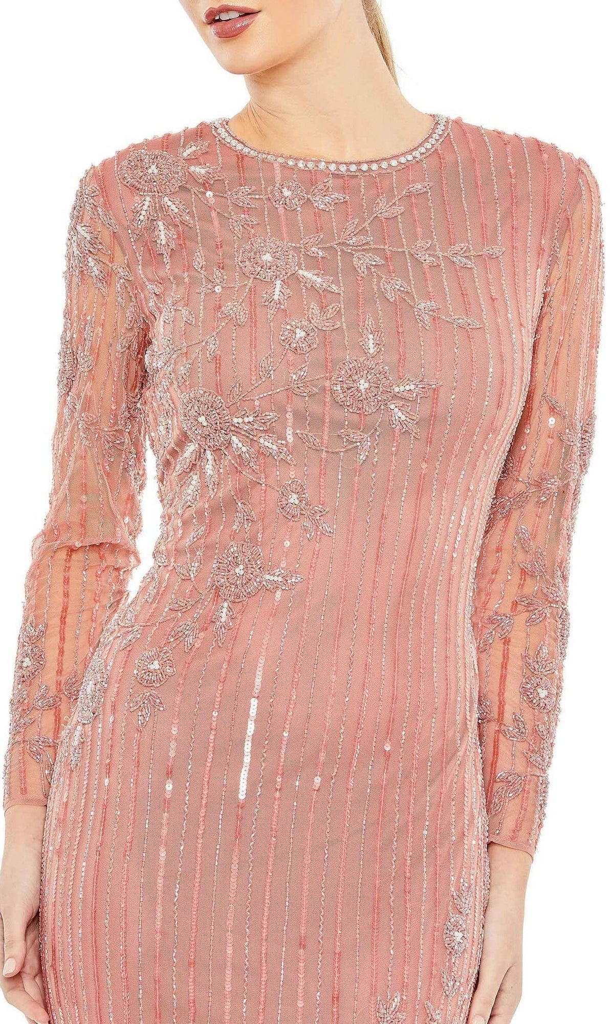 A woman wearing the Mac Duggal 93626 Long Sleeve Sequin Formal Gown, a blush pink evening dress with intricate floral embroidery and beaded stripes.